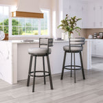 Two gray cushioned bar stools in a kitchen setting with white cabinets and a window view.