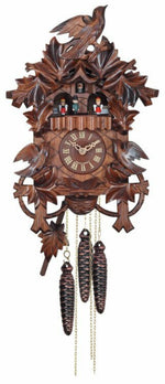 Wooden cuckoo clock with intricate carvings on a white background