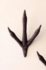 A dark brown, three-clawed bird-of-prey style wall hook with a screw-mounted base, shown against a plain off-white background.
