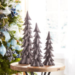Decorative Christmas trees on a wooden table with a festive background