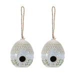 Two ceramic birdhouses with decorative patterns on a white background