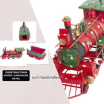 Handmade metal Christmas train model with red and green colors on a white background.