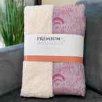 Folded blanket with 'Premium Washables' label on a gray surface