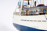 Model of a ship with a white hull and blue bottom on a white background