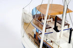Model of a boat with wooden deck and white hull on a light gray background