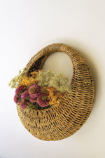 Woven basket with flowers on a white background
