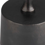 Close-up of a black metal object with a cylindrical shape and rounded top.