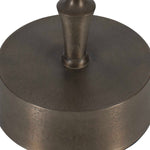 Bronze-colored metal object with a cylindrical top on a white background