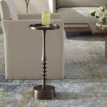 Bronze side table with a glass of water in a living room setting