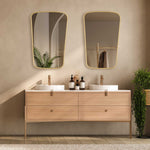 Bathroom vanity with two sinks, mirrors, and decorative items against a beige wall.