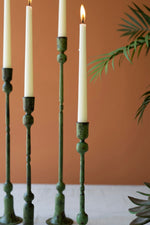Green candle holders with lit candles against a brown background