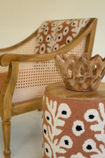 Wooden chair and ottoman with floral patterns in a room setting