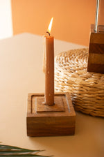 Candle in a wooden holder on a neutral background
