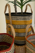 Woven planters with striped patterns on a neutral background