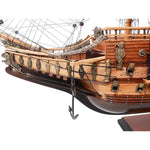 Close-up of a wooden model ship with detailed features on a white background
