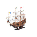 Model of a historical ship with multiple masts and flags on a white background