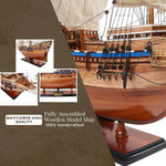 Fully assembled wooden model ship with detailed craftsmanship on a brown background.