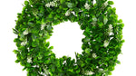 Green leafy wreath with small white flowers on a white background