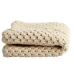 Folded beige blanket on a white background