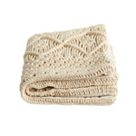 Folded beige knitted blanket on a white background