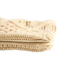 Folded beige textured blanket on a white background