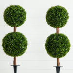Four artificial topiary trees with spherical green shapes on a white background