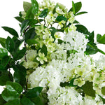 White faux hydrangea and small white blossoms with glossy green leaves, photographed against a plain white background.