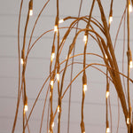 Decorative lighting fixture with branches and small lights on a neutral background