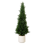 Tall green artificial Christmas tree in a white pot on a white background