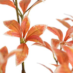 Close-up of orange and red artificial leaves on a white background