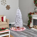 White Christmas tree in a living room with decorations and a fireplace.