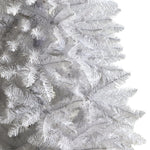 Close-up of a white artificial Christmas tree with detailed branches.