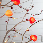 Six-foot white decorative tree with glowing red and pink heart ornaments.