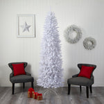 White Christmas tree in a room with gray chairs, red pillows, and decorative wreaths on a white wall.