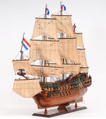 Wooden model ship with sails and flags on a white background
