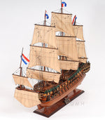 Model of a three-masted sailing ship with detailed sails on a white background