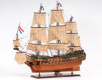 Model of a three-masted sailing ship with flags on a white background