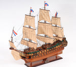 Model of a three-masted sailing ship with flags on a white background