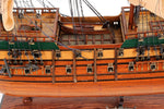 Wooden model ship with detailed rigging on a white background
