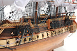 Close-up of a model ship with detailed rigging and wooden structure.