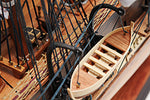 Model ship with a small wooden boat attached to the deck
