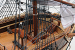 Close-up of a model ship's deck with wooden planks and ropes.