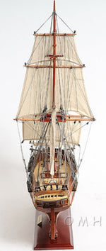 Model of a tall ship with multiple masts and sails on a white background