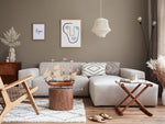 Modern living room with a gray sofa, wooden armchair, and decorative items.