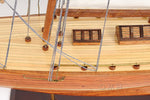 Close-up of a wooden model ship with ropes and a visible brand name.