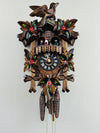 Wooden cuckoo clock with intricate details on a white background