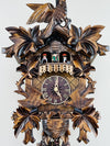 Wooden cuckoo clock with intricate carvings on a white background