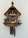 Wooden cuckoo clock with detailed design on a white background