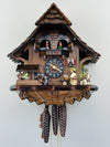 Wooden cuckoo clock with detailed design on a white background