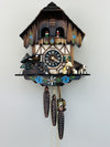 Wooden cuckoo clock with detailed design on a white background